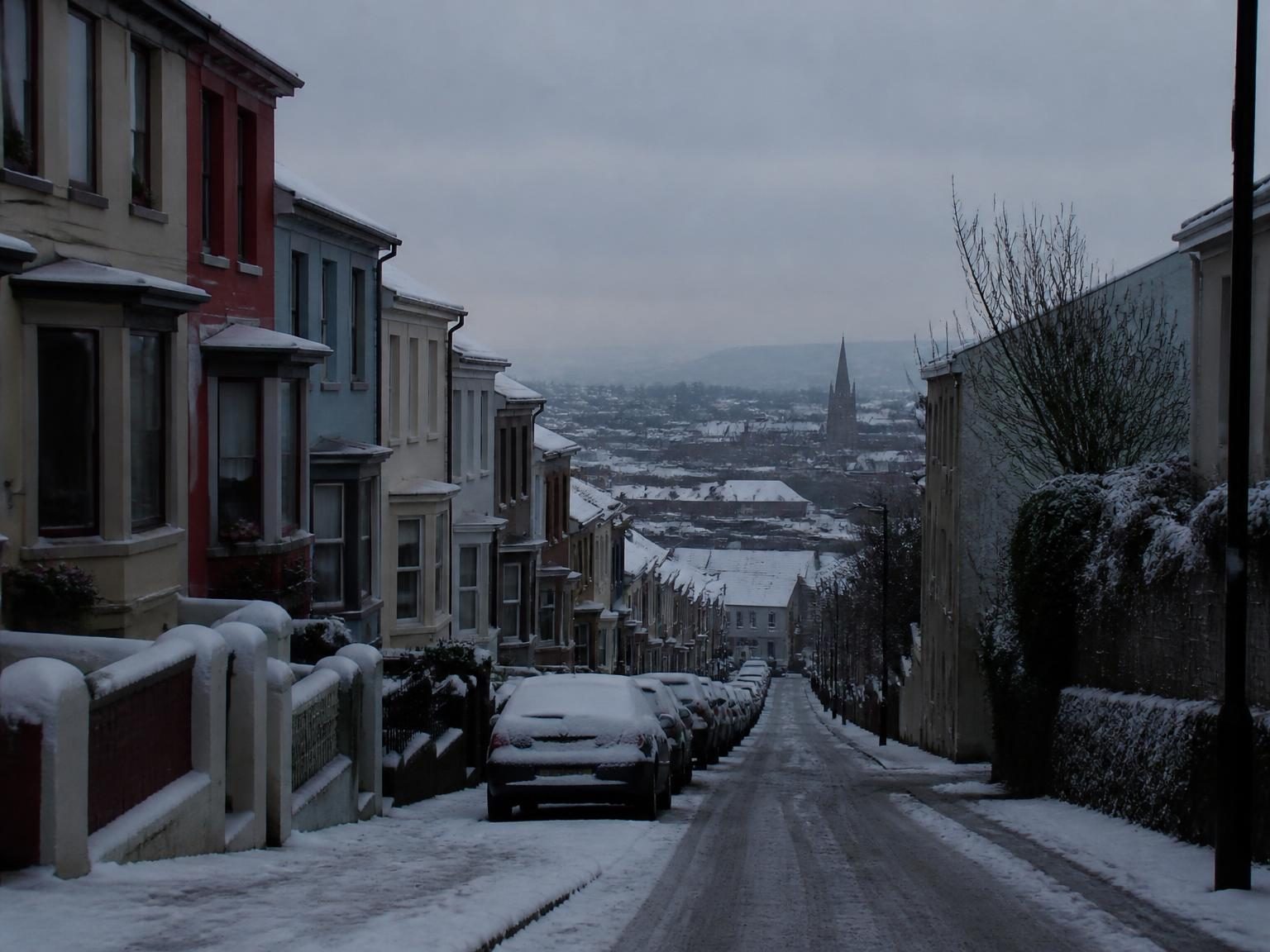 Rare snow on a Cork terrace street, underexposed so the snow looks dirty grey.