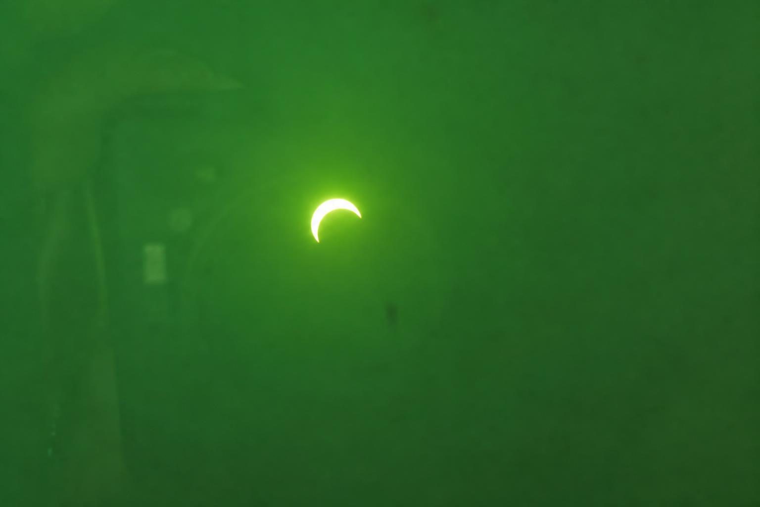 Partial eclipse shot through welding glass, all green