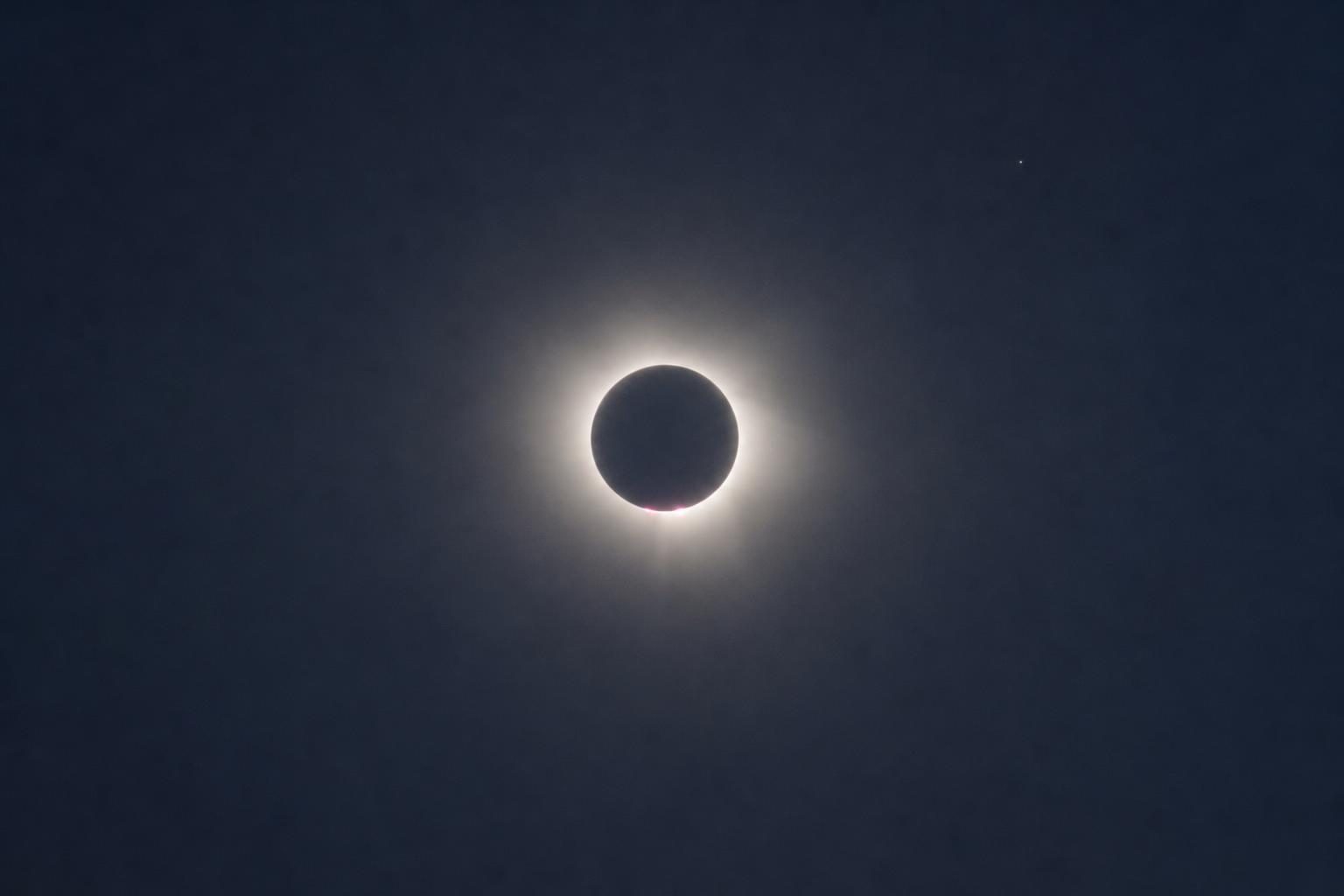 Total solar eclipse corona with pink prominences